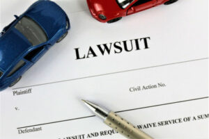 Lawsuit paper with two toy cars