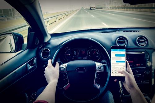 A driver texting while on the interstate.