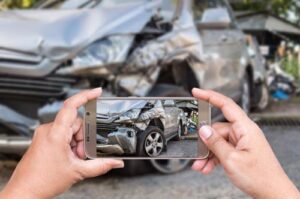 Person taking picture of car accident for personal injury case